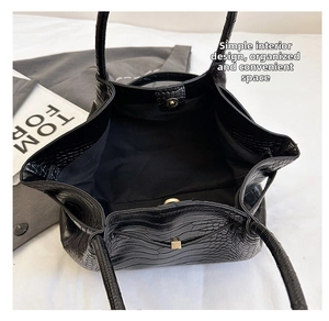 Spacious interior of a black crocodile-embossed leather tote bag with minimalist design