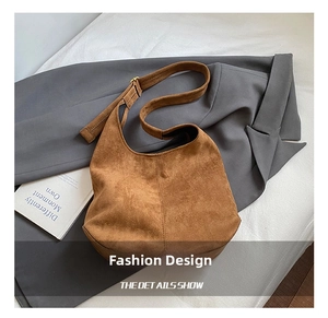 Détail du sac hobo en daim marron avec bandoulière réglable et boucle en métal doré