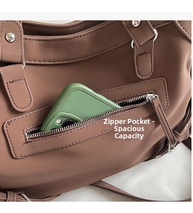 Détail du sac cabas marron montrant la poche zippée avec un smartphone pour la taille