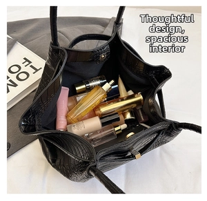 Top view of crocodile embossed handbag showing spacious interior for cosmetics and skincare