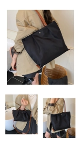 Detail van grote zwarte nylon shopper en kleine crossbody tas met leren handgrepen