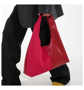 Detail of red tote bag featuring contrast stitching and suede leather patchwork texture