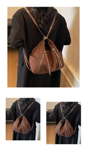Detail of dark brown suede backpack featuring long fringe tassels and golden zippers