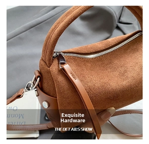 Detail des silbernen Reißverschlusses an der braunen Wildledertasche mit langem Zieher