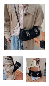 Détail du sac croissant en daim noir avec doubles poches avant et boucles métalliques