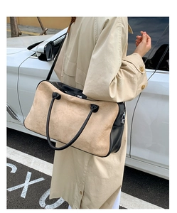 Detail of color-block tote bag with beige suede and black leather texture in urban street style