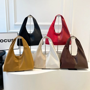 French vintage half-moon tote bags in various colors on a white minimalist display