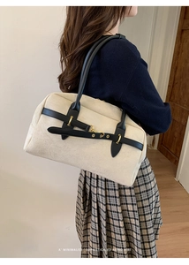 Close-up of cream Boston bag with leather straps and gold hardware for a retro vibe