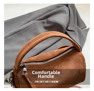 Detail des Wildledergriffs und Metallreißverschlusses der braunen Vintage-Tasche