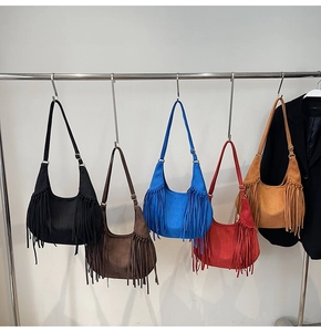 Sacs hobo en daim colorés avec de longues franges suspendus sur un support en métal