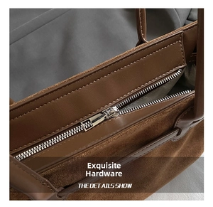 Dettaglio della cerniera in metallo argentato e cuciture su borsa tote in pelle scamosciata