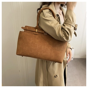 Brown suede tote bag on model wearing trench coat showing large capacity and soft texture