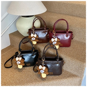 Détails des mini sacs seaux avec charm ourson et boucles métalliques sur les anses
