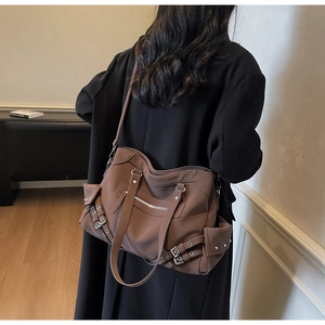 Detail view of large dark brown retro tote bag with multiple pockets and silver rivets