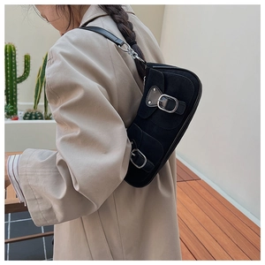 Gros plan du sac croissant en daim noir avec boucles argentées et bandoulière chaîne