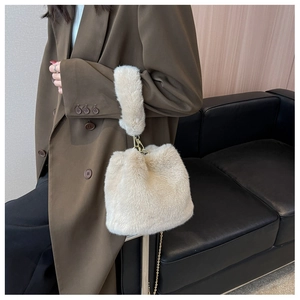 Détail du sac seau en fausse fourrure crème avec poignée peluche et chaîne dorée