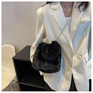 Détail du sac à bandoulière en fausse fourrure noire avec chaîne dorée et texture douce