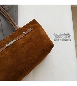 Detail shot of brown suede tote bag featuring silver hardware and soft fabric texture