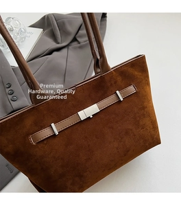 Detail of brown suede tote bag featuring silver metal buckle and premium texture