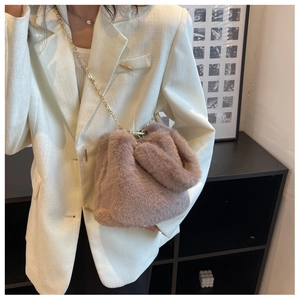 Détail du sac seau en fausse fourrure rose poudré avec bandoulière chaîne dorée