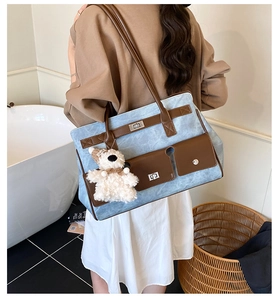 Detail of blue marble texture tote bag with brown pockets and plush bear charm decoration