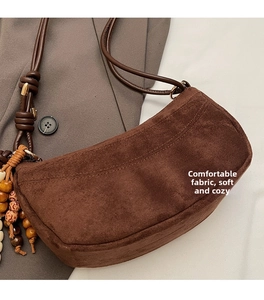 Detail of vintage matte brown suede crossbody bag with decorative wooden beads and cord
