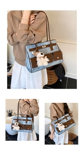 Close-up of contrast stitching, brown leather pockets and soft lamb plush charm on tote bag