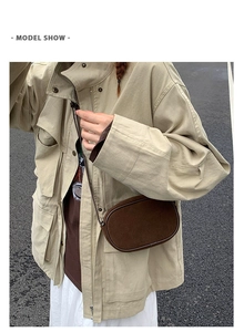 Street style view of a dark brown suede crossbody bag paired with a beige utility jacket