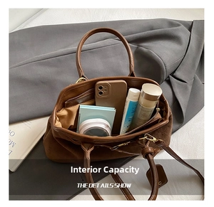 Deep brown suede handbag interior view showing spacious compartment and zip pocket