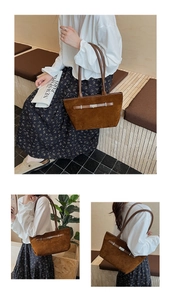 Dettaglio della grande borsa tote in pelle scamosciata marrone con fibbia e manici lunghi