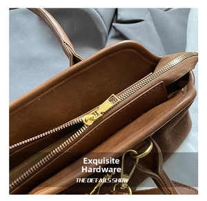 Close-up of golden zipper and hardware details on caramel suede tote bag