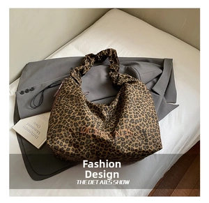 Detail of leopard print tote bag with soft pleated handle and embroidered lettering
