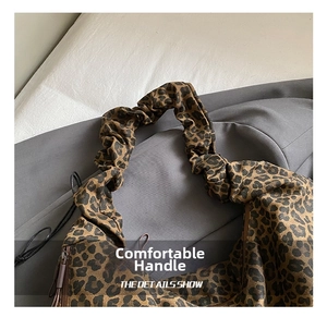 Detail view of leopard print tote bag with ruffled handle and smooth zipper closure