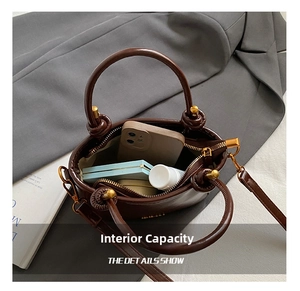 Vue intérieure montrant la capacité du sac seau en cuir marron avec maquillage