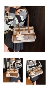 Detail of canvas and leather tote bag featuring a cute teddy bear plush accessory