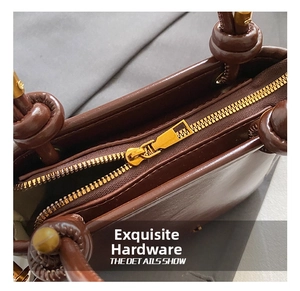 Vue détaillée de la fermeture éclair dorée et des ferrures du sac en cuir marron