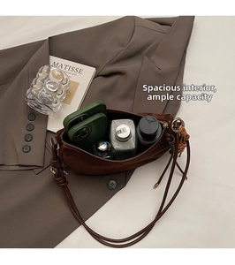 Detail view of the spacious interior compartment of the brown matte crescent shoulder bag