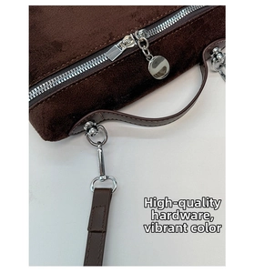 Close-up of premium silver hardware and suede texture on dark brown handbag