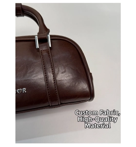 Primer plano del bolso Boston marrón oscuro con cuero de cera de aceite y logo de corazón