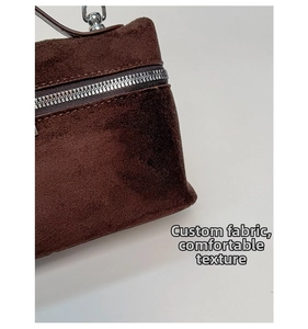 Macro shot of dark brown suede handbag material and premium silver metal zipper detail