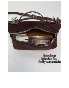 Detail view of the brown suede handbag's spacious interior and secure silver zipper