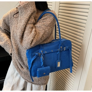 Detail view of royal blue faux suede tote bag with decorative strap and mini pouch
