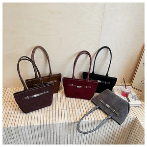 Five assorted bucket bags in premium suede finish arranged on a minimalist stone display