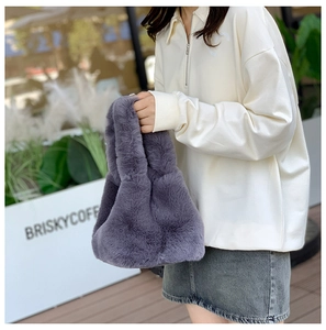 Detail of dark grey plush bucket bag showing soft faux fur texture and handle