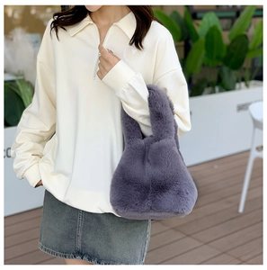 Detail of plush faux fur bucket bag in grey-purple paired with heart-embroidered sweatshirt