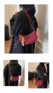 Macro shot of burgundy faux shearling crescent bag with colorful wooden bead tassel