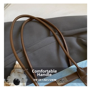 Detailed view of silver twist-lock closure and leather handles on blue tote bag
