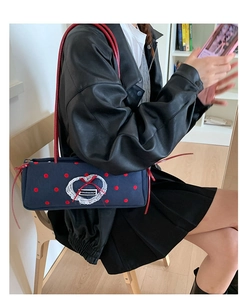 Dettaglio della borsa in tela blu scuro a pois rossi con pizzo a forma di cuore