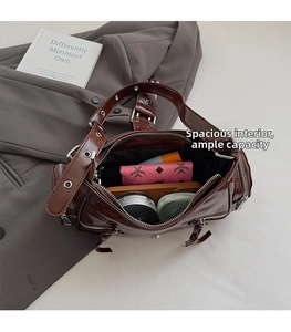 Detail of dark brown glossy patent leather motorcycle bag interior with daily essentials