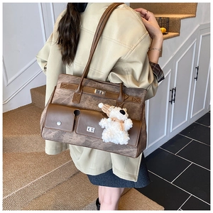 Close-up of vintage brown tote bag with functional pockets and plush bear ornament